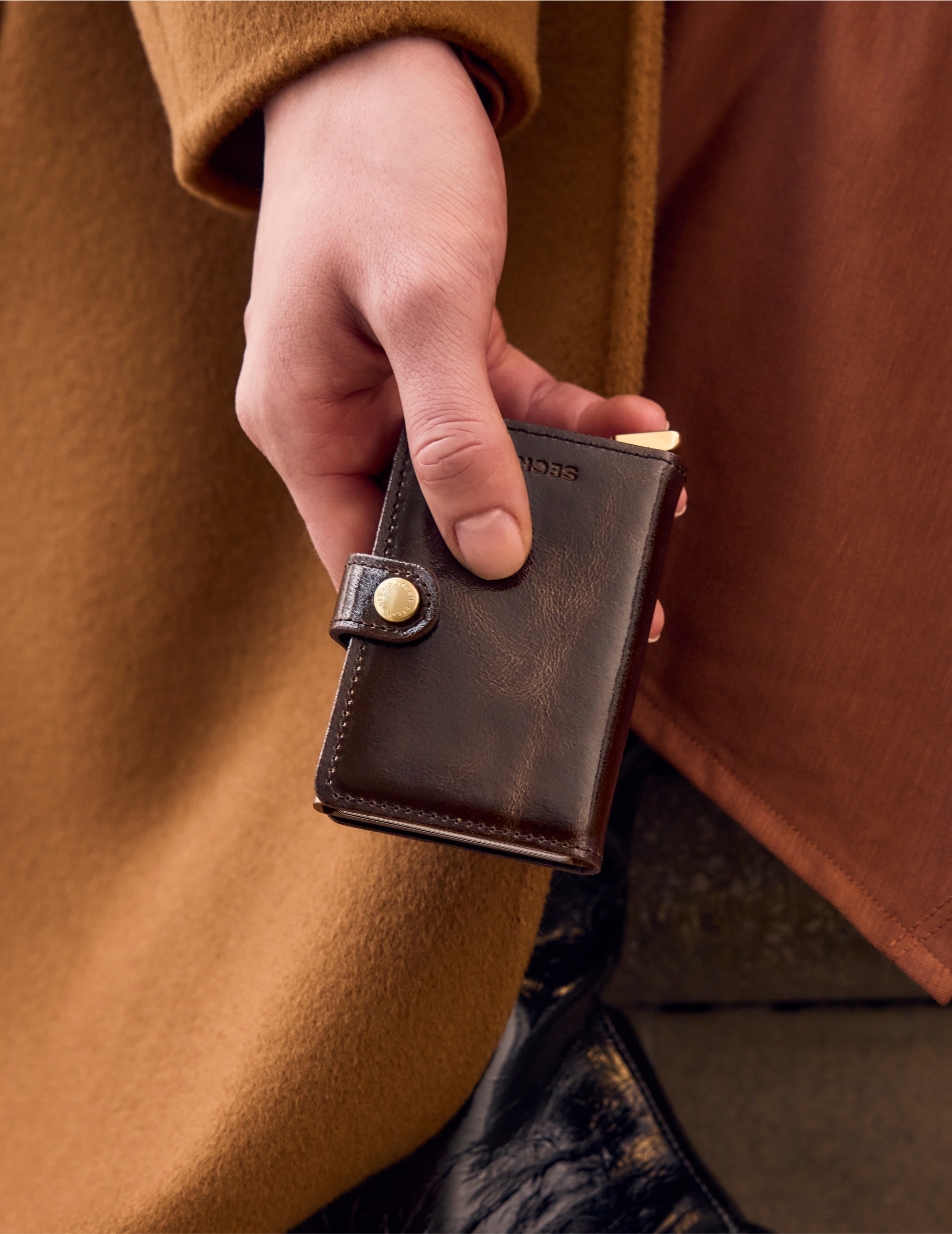 A shiny brown card holder, matched with brown shiny shoes